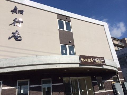 和を感じる落ち着いた色合いと、しっかりとした自体で施設名が書かれている。玄関には半円形の屋根もついている。