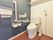 フラットな床に設置されたトイレは広く清潔である。手すりやひじかけが設置されているので安全に利用できる。