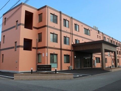 「サンスマイル小山」の外観。あたたかみのある色合いの建物。