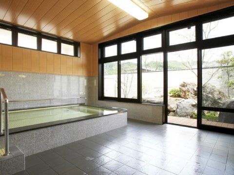 設置された窓から中庭が見える。開放的な浴室に完備されている浴槽の周囲には、手すりが取り付けられている。