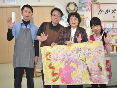 笑顔で手を振っていて、親しみやすくアットホームな雰囲気を醸し出すスタッフたち