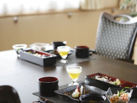 料亭のように黒塗りの器に盛り付けられ、飲み物と共にテーブルに並べられた料理
