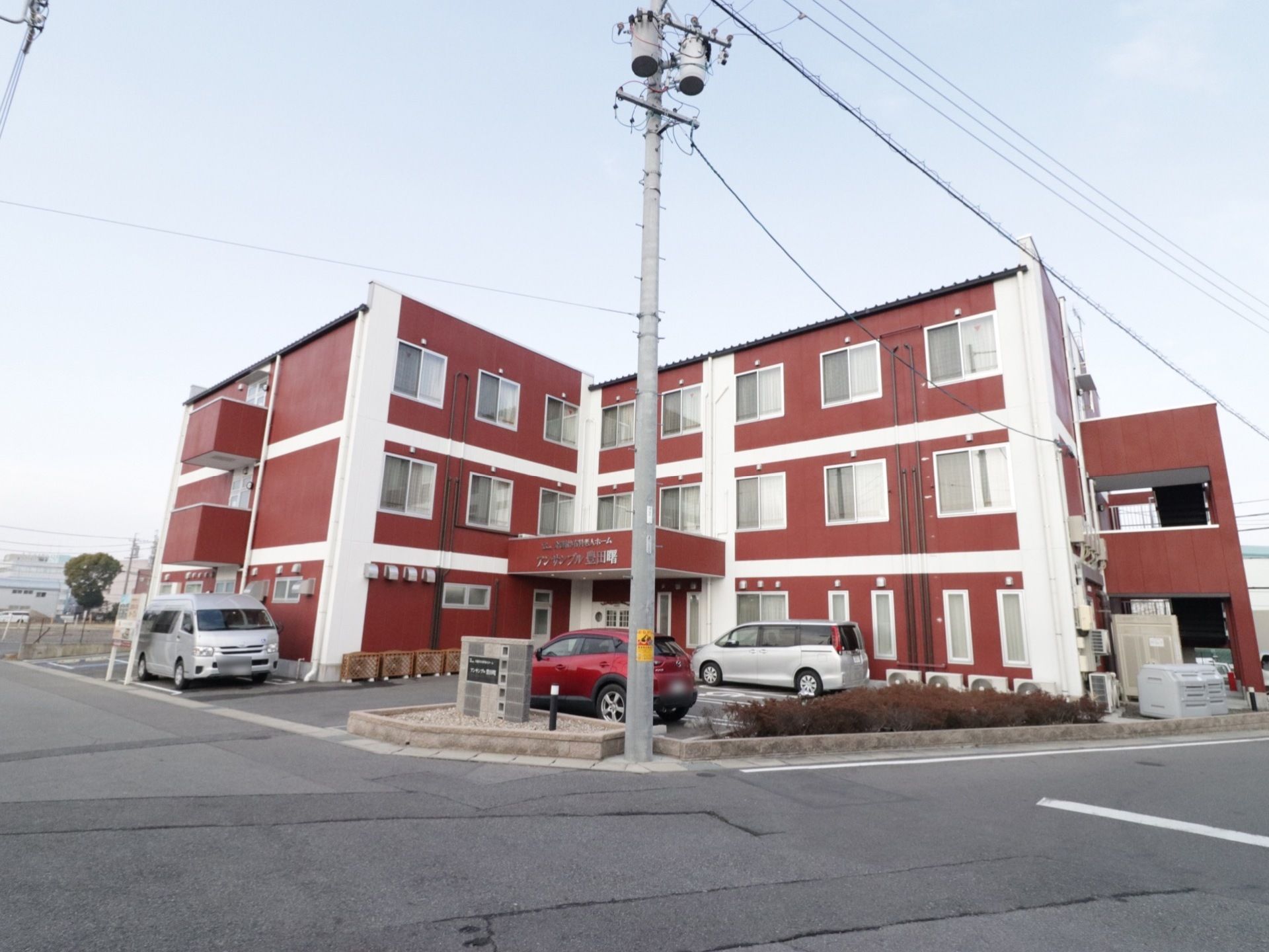 えんじと白のコントラストがひときわ目を引く建物である。駐車場スペースもあり、周りには高い建物がない。