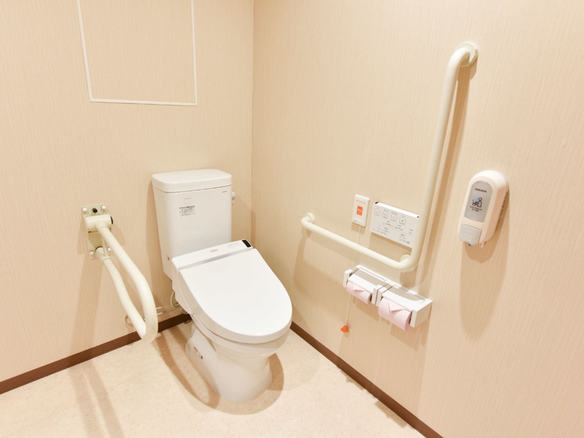 洋式トイレ。両サイドには手すりがついており、高齢者でも利用しやすい。緊急時の呼び出しボタンが設置されている。