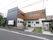 2階建てとなっている施設はL字型の建物となっている。左手には大きめの看板があり、施設名と人の写真を見ることができる。