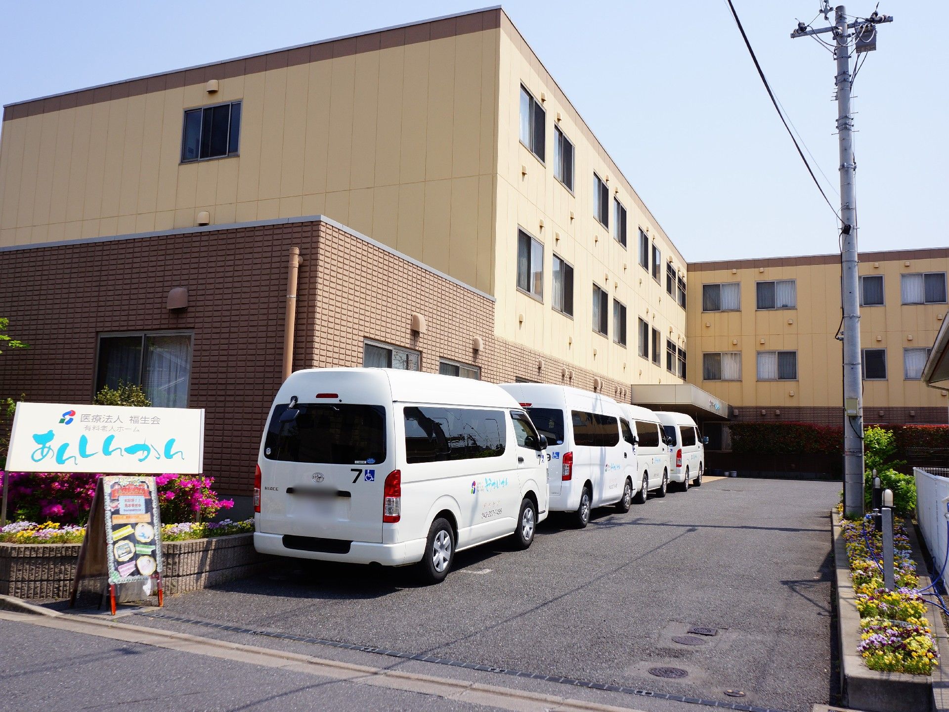 駐車場の脇に花壇が設けられている。施設の外観。