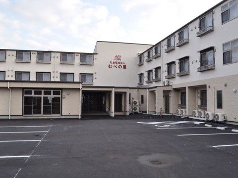 白やベージュを中心とした、シンプルで落ち着いた雰囲気の外観。十分な広さの駐車スペースも確保されている。
