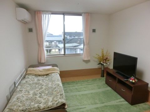 居室はくつろぎやすさが重視されており、ベッドやテレビ、観葉植物が配置されている。落ち着いてゆっくりすごせる居室である。