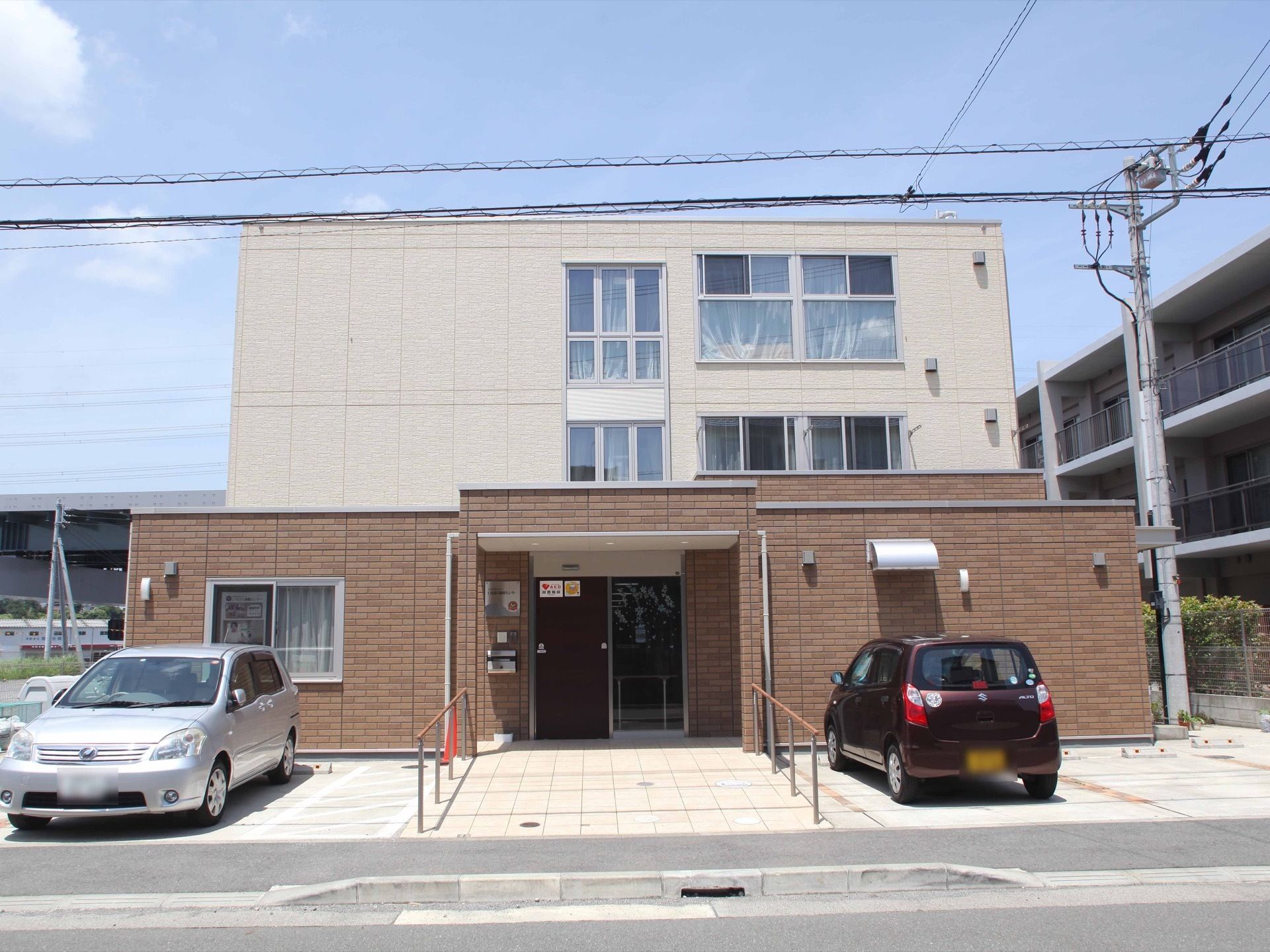 ３階建ての建物になっていて、１階部分はレンガ調の壁になっている。玄関に向かってスロープになっており、手すりが備えてある。