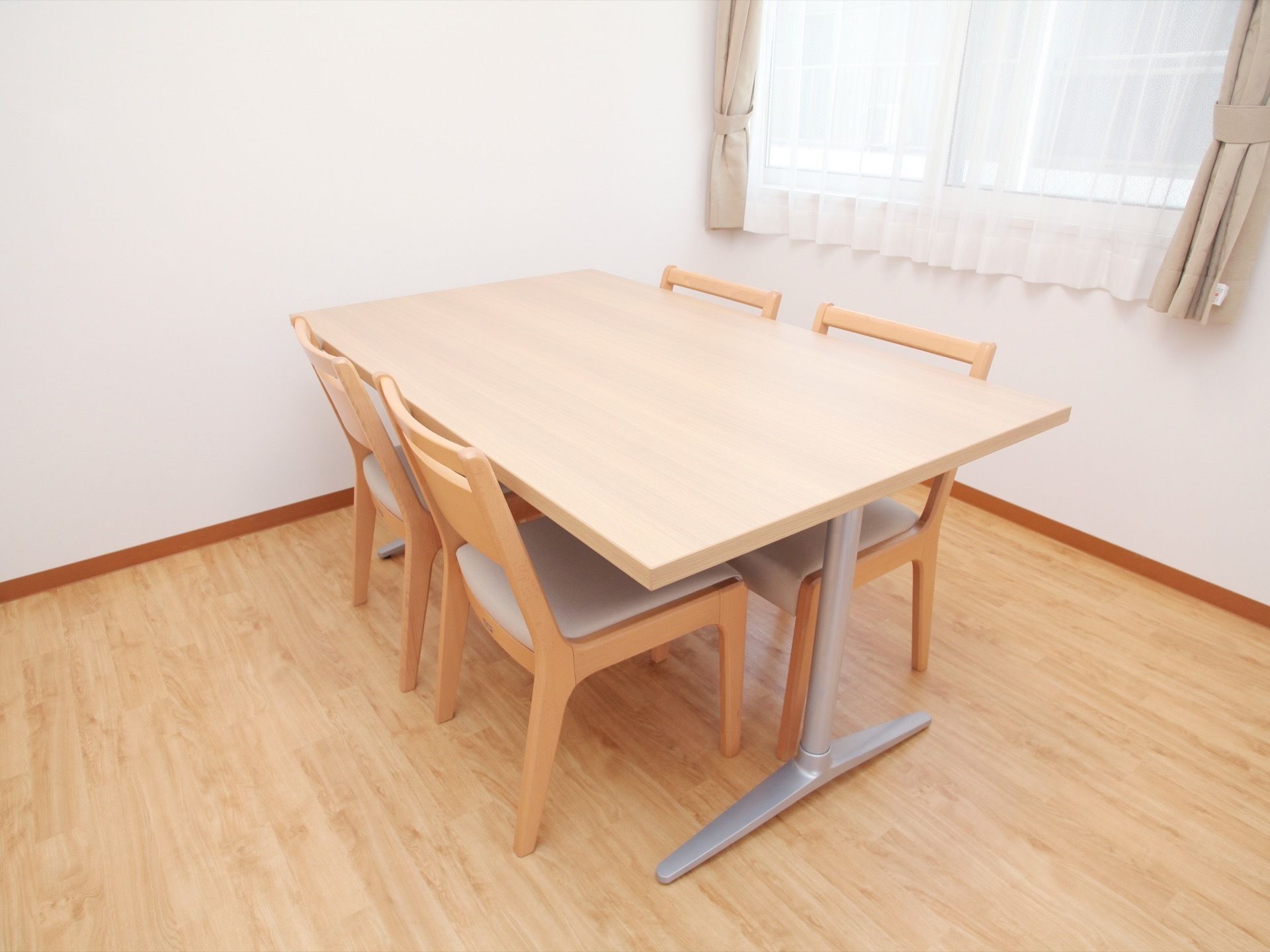 フローリングの床と座りやすい椅子のある、洋風の部屋である。車椅子をご利用の方でも使いやすい高さのテーブルである。