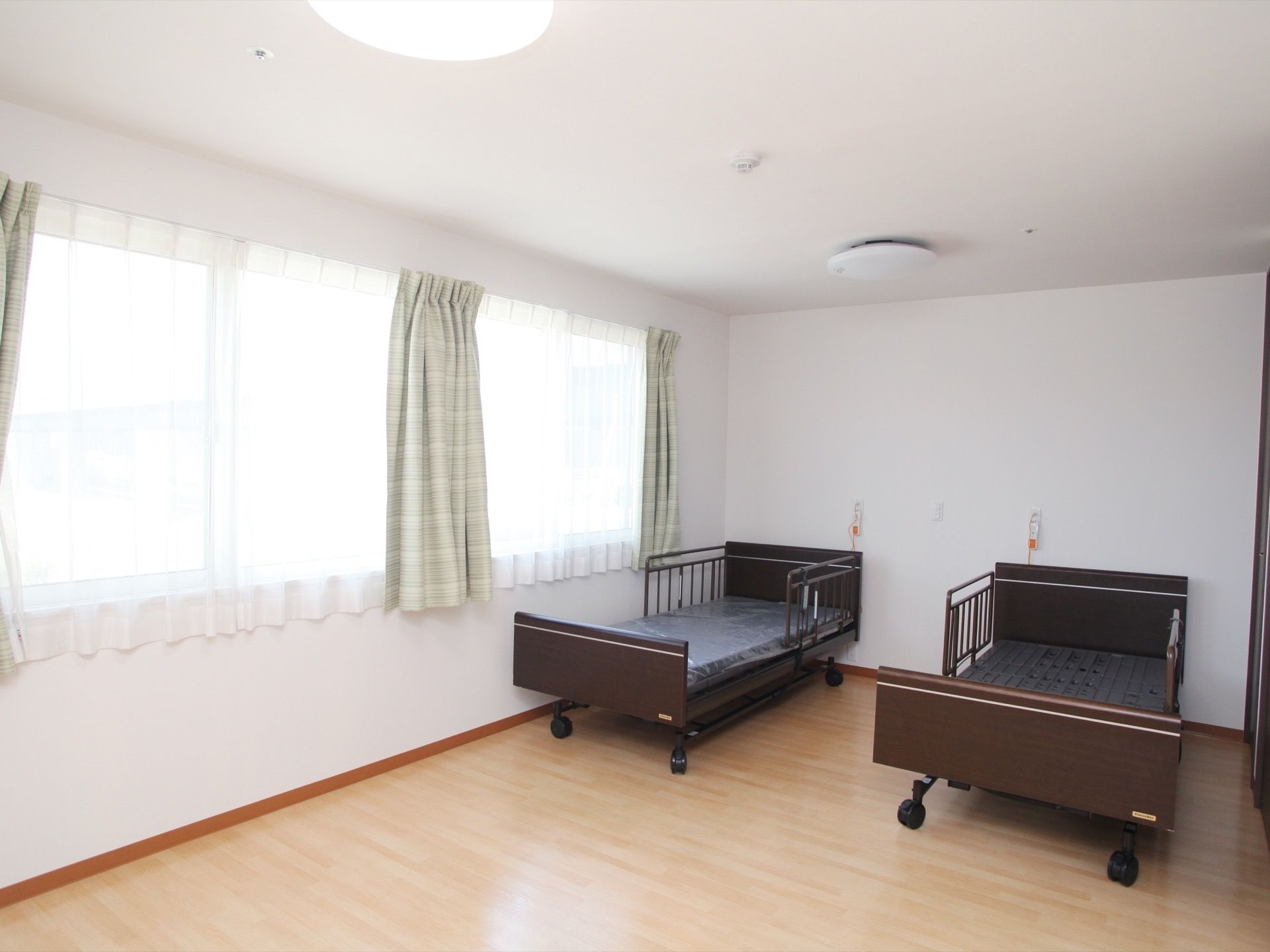 居室には大きな窓があり、部屋いっぱいに光が差し込んでいる。ベッドを２つ置いても、スペースに余裕がある。