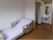 左側には介護用ベッドがあり、その奥にはトイレと洗面台が設置されている。トイレの入口はカーテンになっている。