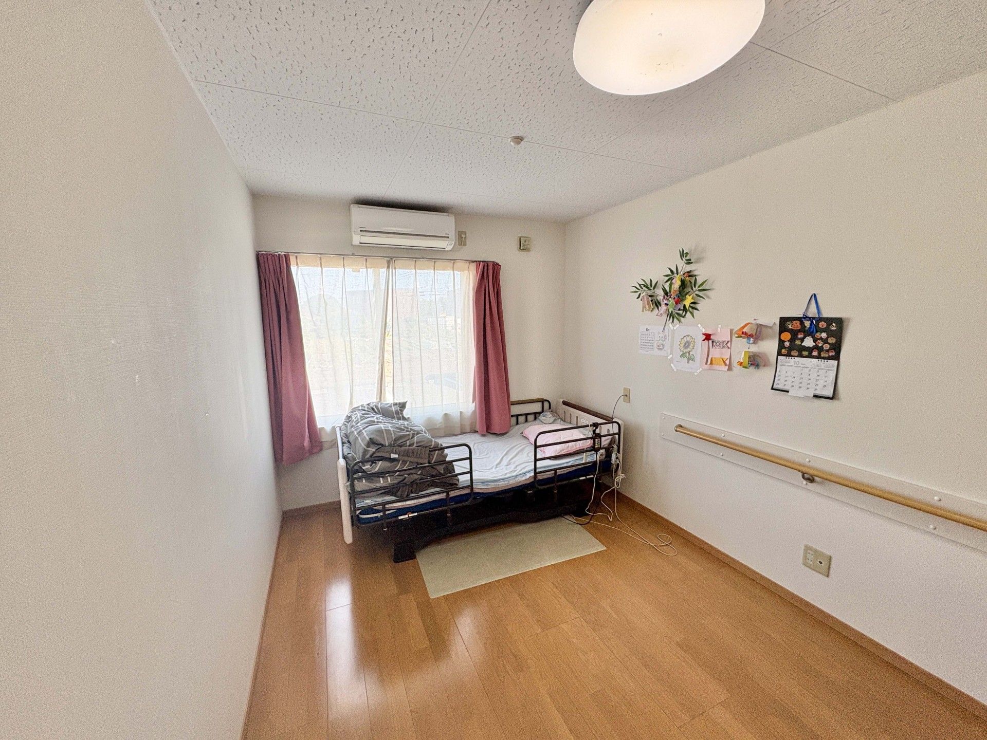 窓際のベッドと壁飾り