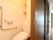 トイレは照明が非常に明るく、便器奥の壁には小型の収納スペースが設置されている。壁には施設スタッフ呼び出し用のボタンが備わっている。