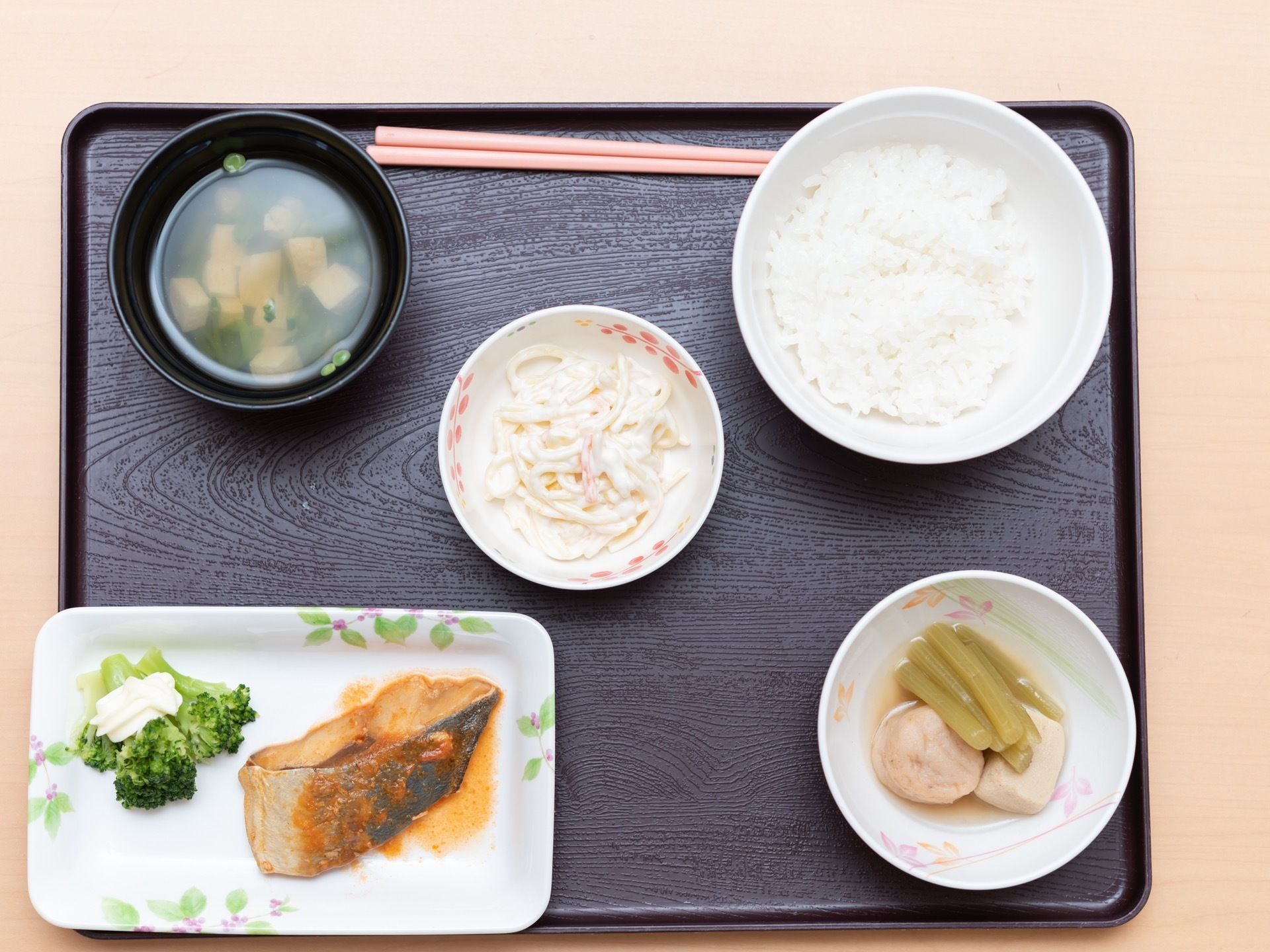 白米、お豆腐とネギの味噌汁、フキの煮物、魚の煮付けとブロッコリー、スパゲッティサラダが和盆にセットされている。