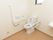 広いスペースに洋式トイレが設置されている。便座の横や壁には手すりがあり、緊急通報用のボタンもついている。