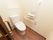 引き戸を開けると洋式トイレがある。壁にはＬ字型の手すりが設置され、膝の高さほどの場所にはナースコールがついている。