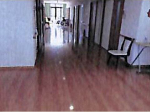 床がフローリングで壁際に椅子が置かれている、居室前の廊下