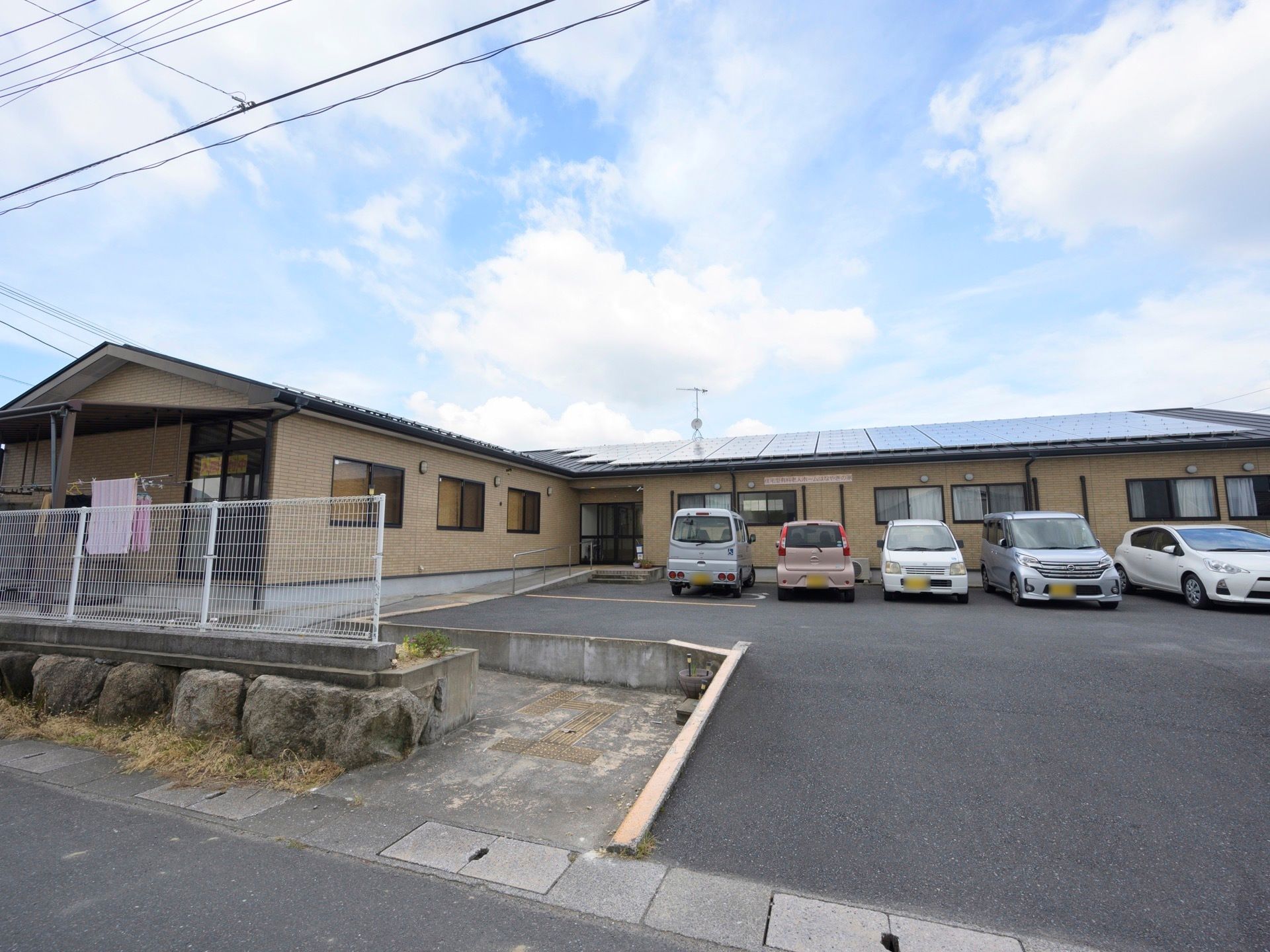 車道から敷地内へは緩やかな登り坂になっている。玄関まではスロープが設けられ、手すりも設置されている。