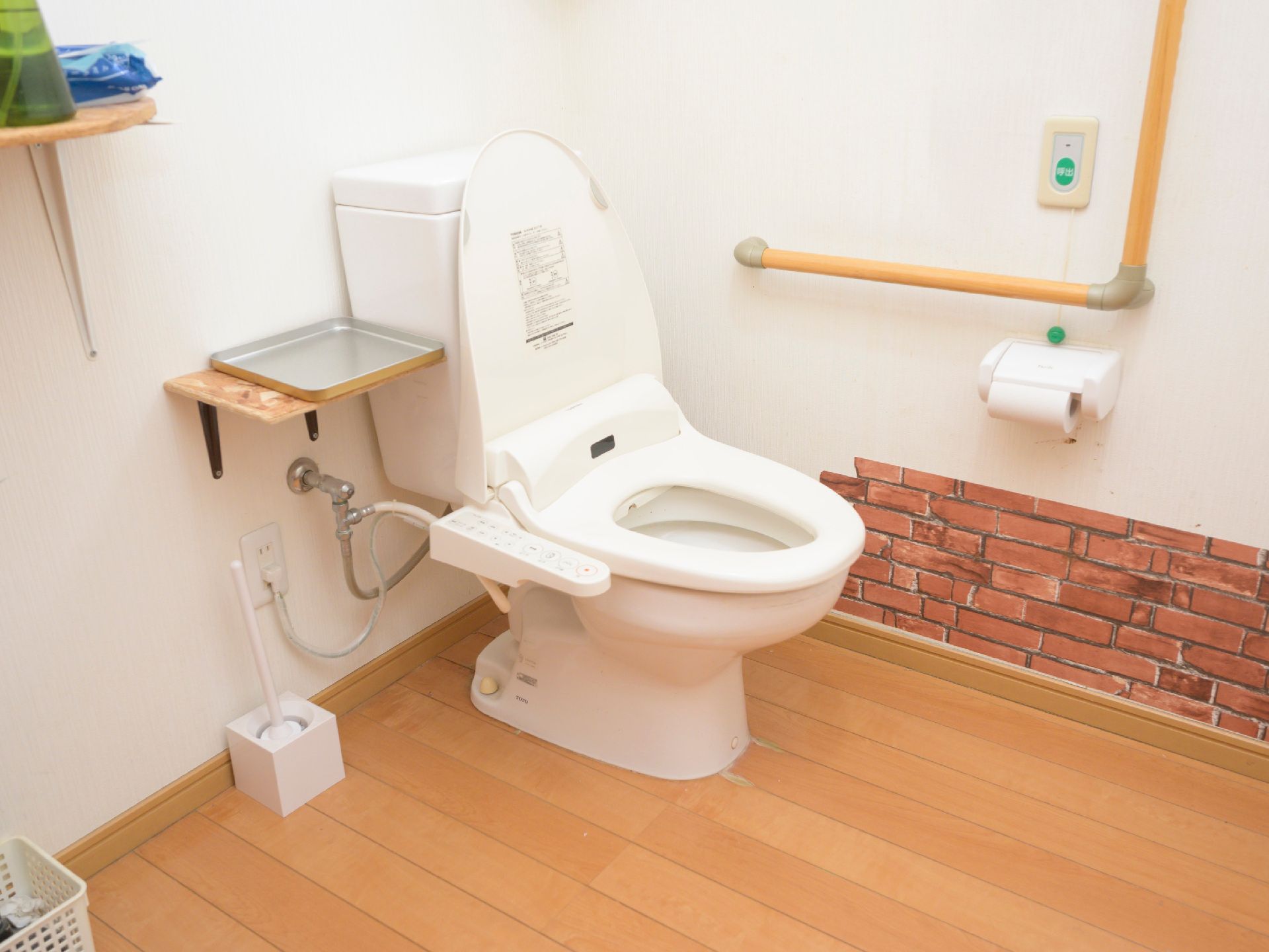 温水洗浄機能付きのトイレと、壁に設置された非常ボタン