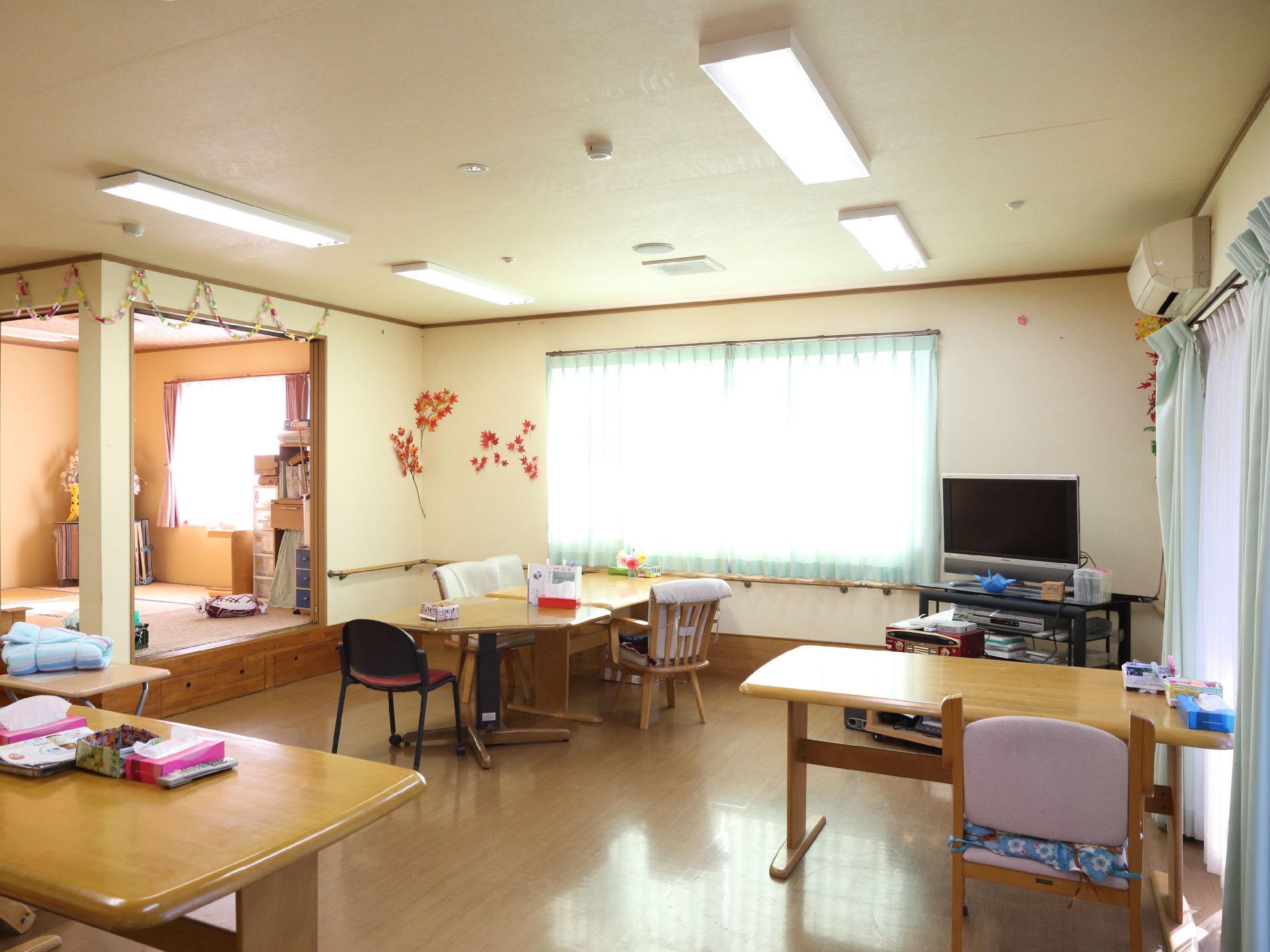 広々とした共有スペースのリビングルームには、椅子やテーブルが置かれている。また壁には空調設備を完備している。