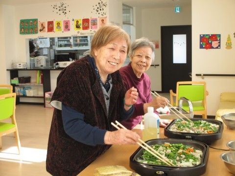 食堂で、ホットプレートを使い料理を楽しむ２人の女性