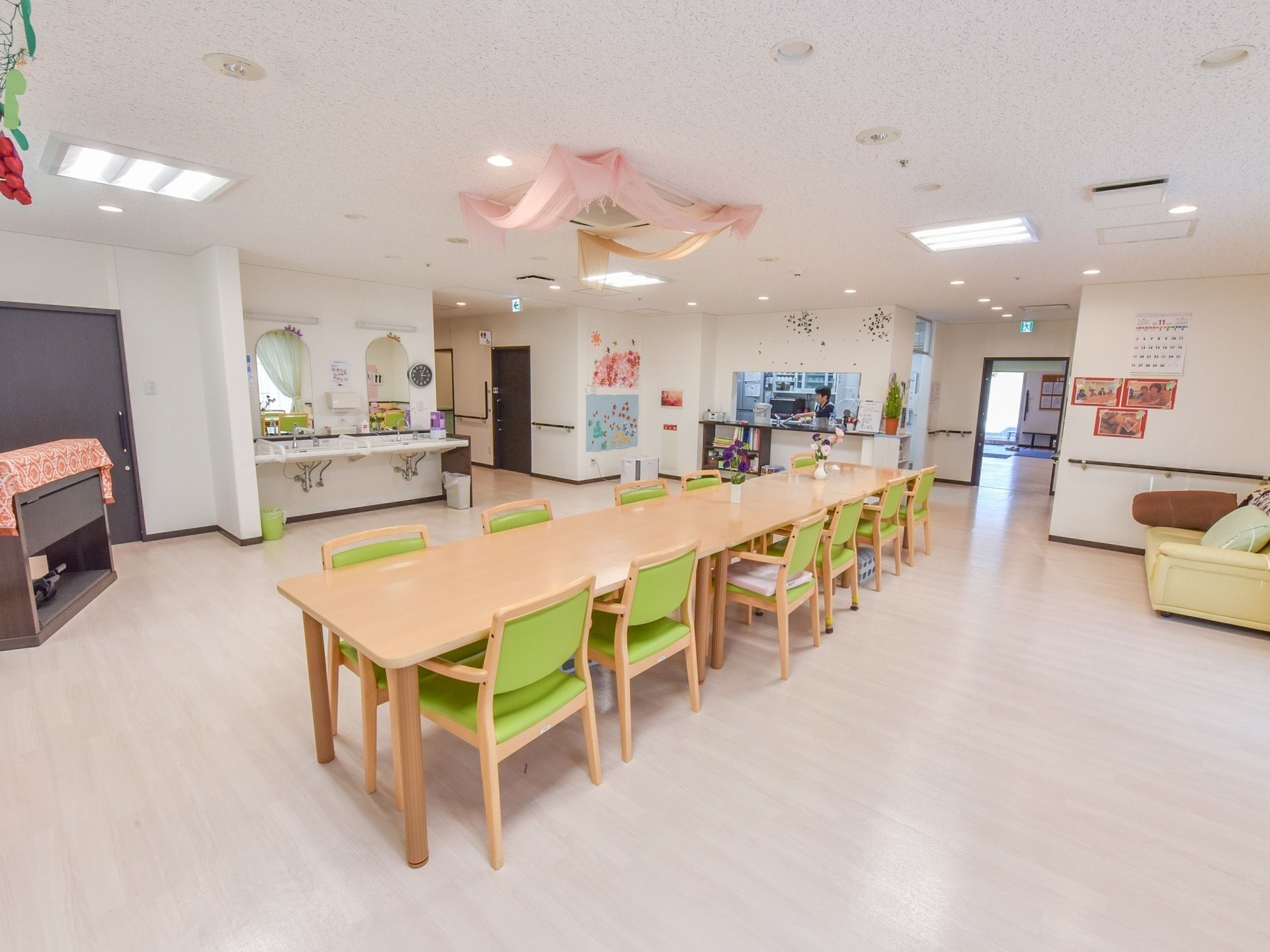 広いオープンスペースの食堂には、着席するテーブルと椅子の近くに洗面台を備え付け、入居者様が食事前に手を洗い易く工夫している。