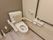 トイレの便座は、両脇に肘置き兼手すりの付いた洗浄機能付き介護用を採用。壁には、縦方向と横方向の手すりを付けて安全な立ち座り姿勢を支えている。