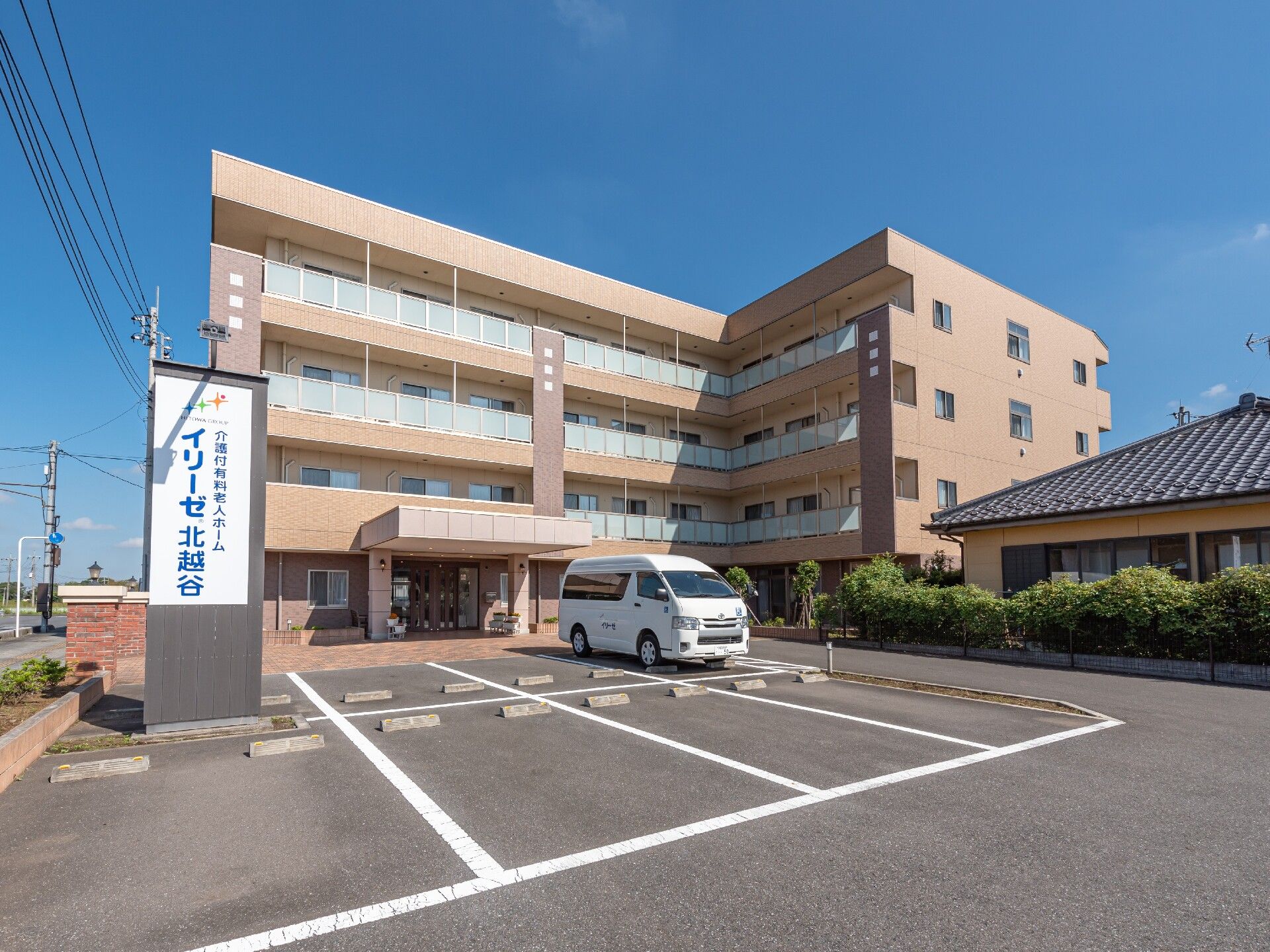 敷地の入り口にレンガ造りの柱が二本立っている。通路は多色使いのタイル張りで、駐車スペースはアスファルトである。