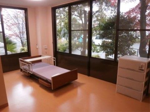 角部屋の居室には、窓から見える景色が広がり開放感がある。介護用ベッドや呼び出しブザーが設置されており、安心してお休みいただける。