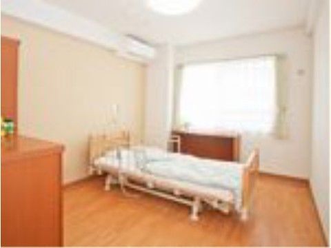 居室に置かれた、リモコンで操作可能なリクライニングベッド