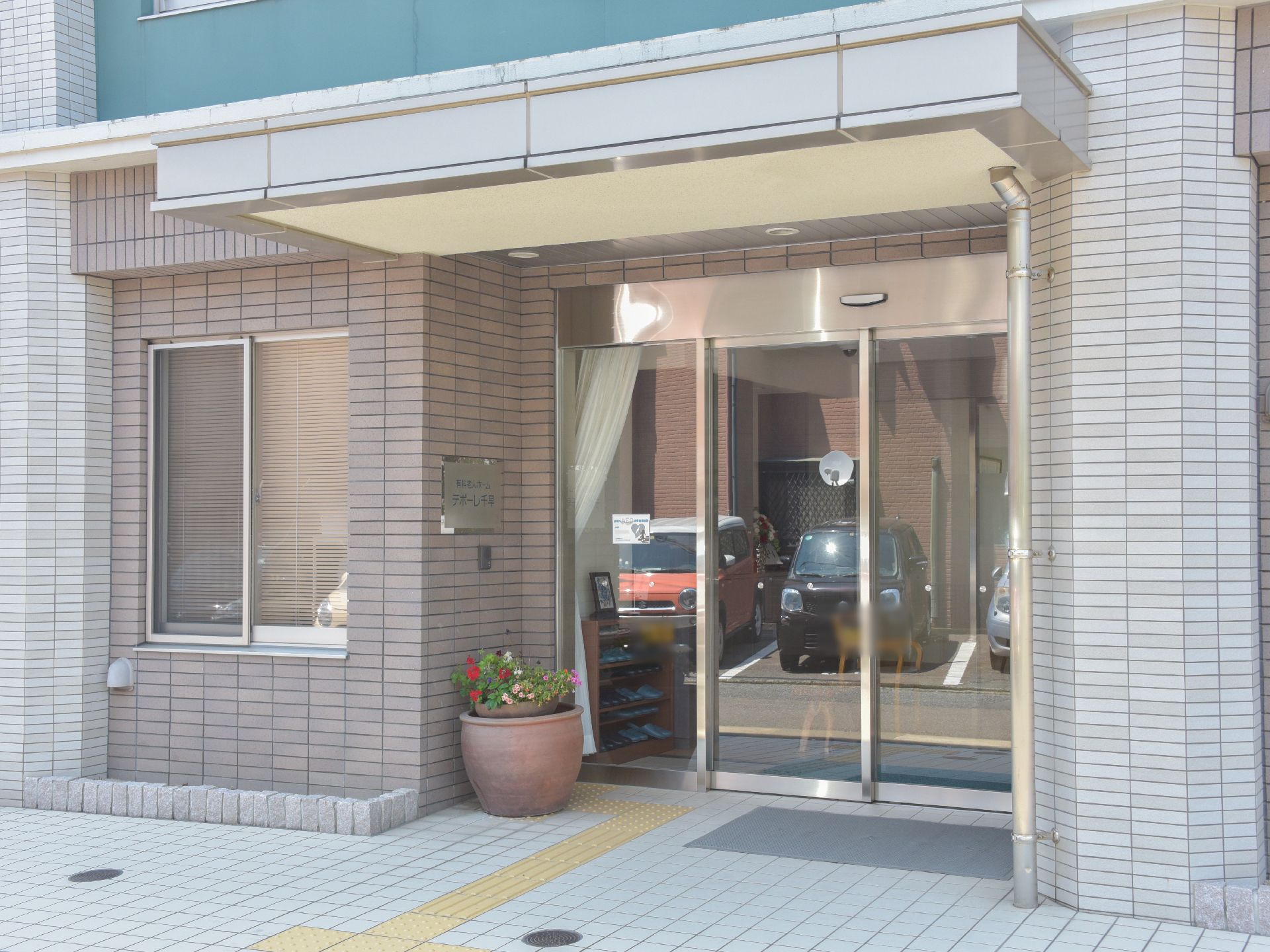 シンプルな作りの入口であるが、外観はモダンな雰囲気がある。また屋根もあるので雨の日の車の乗り降りなども安心である。