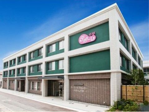 緑色の外壁が特徴的な３階建ての大きなグループホーム