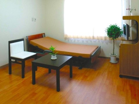 居室には、身体の傾きを自由に調節できる機能が備わったベッドが設置されている。ベッドの向かいにはコンパクトなサイズのテレビが置かれている。