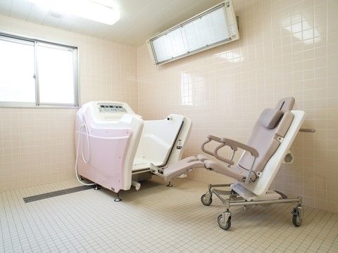 チェアインタイプの浴槽と暖房が備え付けられている浴室