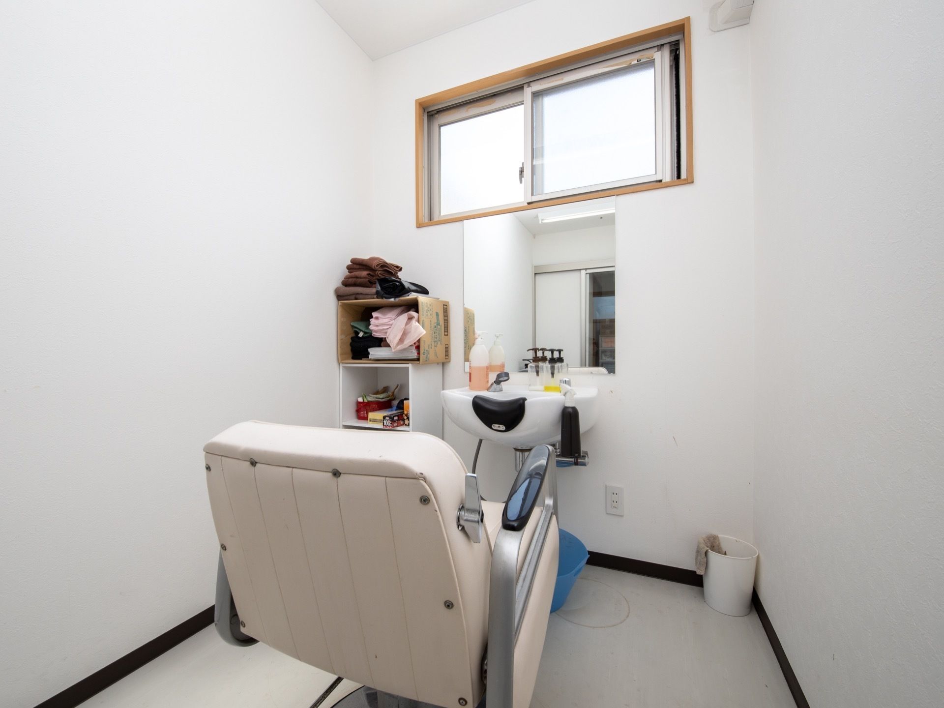 白い大きな革張りの椅子と、シャワー台が設置された小部屋がある。棚があり、シャンプーやタオルなどが置かれている。