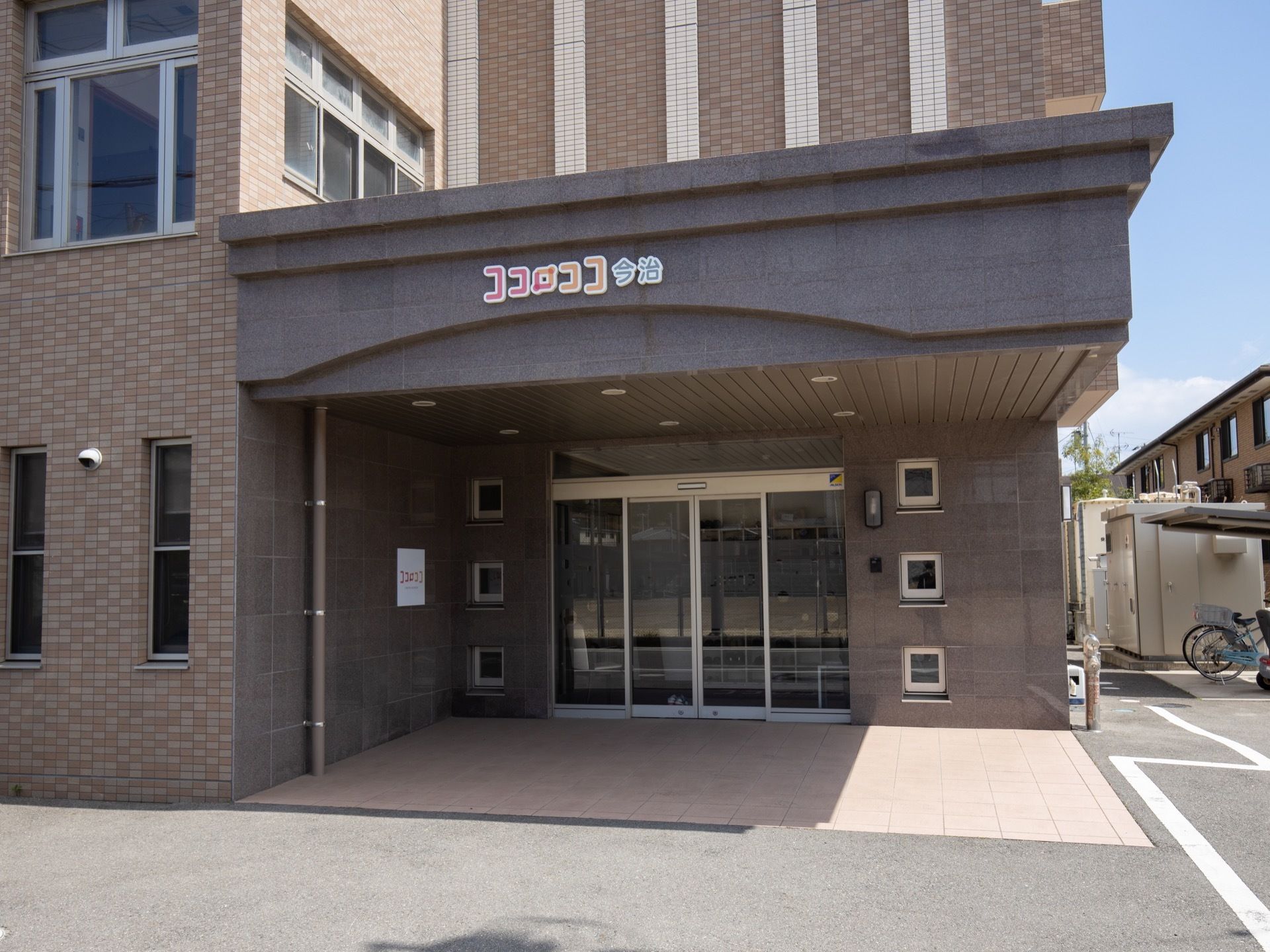 建物の角に玄関があり、車が横つけできるようになっている。自動ドアで、左右に大きく開くので出入りしやすい。