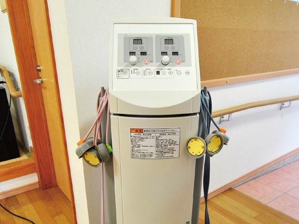 壁にコルクボードと木製の手すりが設置されている廊下