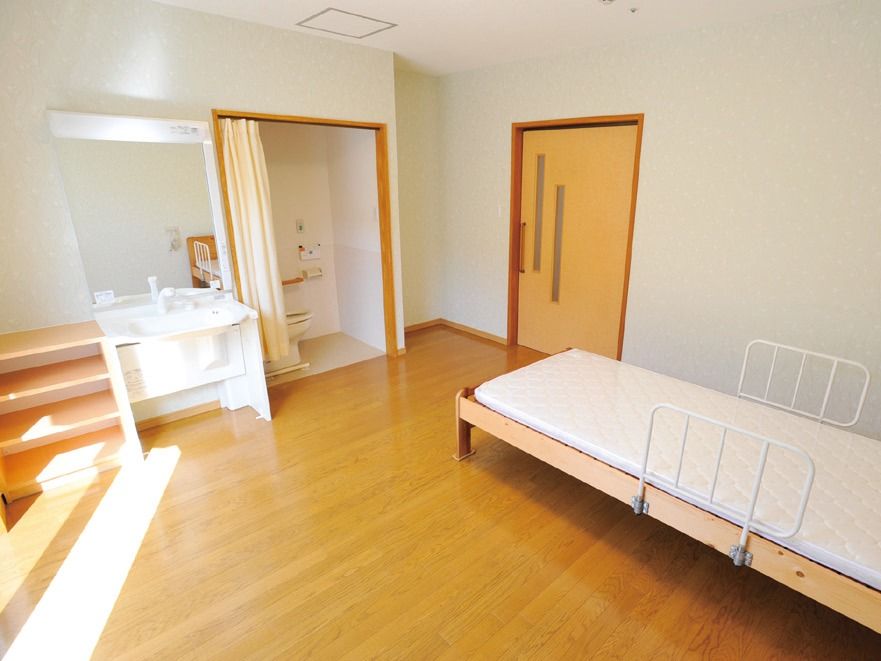 床はフローリングであり扉は木製のため、部屋からは木の温もりを感じることができる。左側からは日の光が差し込んでいる。