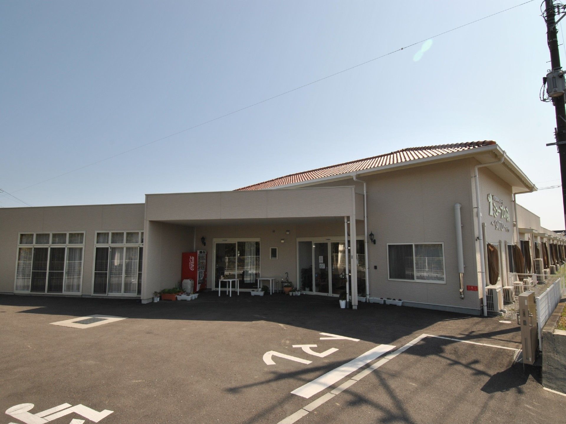 明るい空の下に広大に建てられた施設の外観。広い駐車場から段差もなく、スムーズに中に入っていただくことができる。