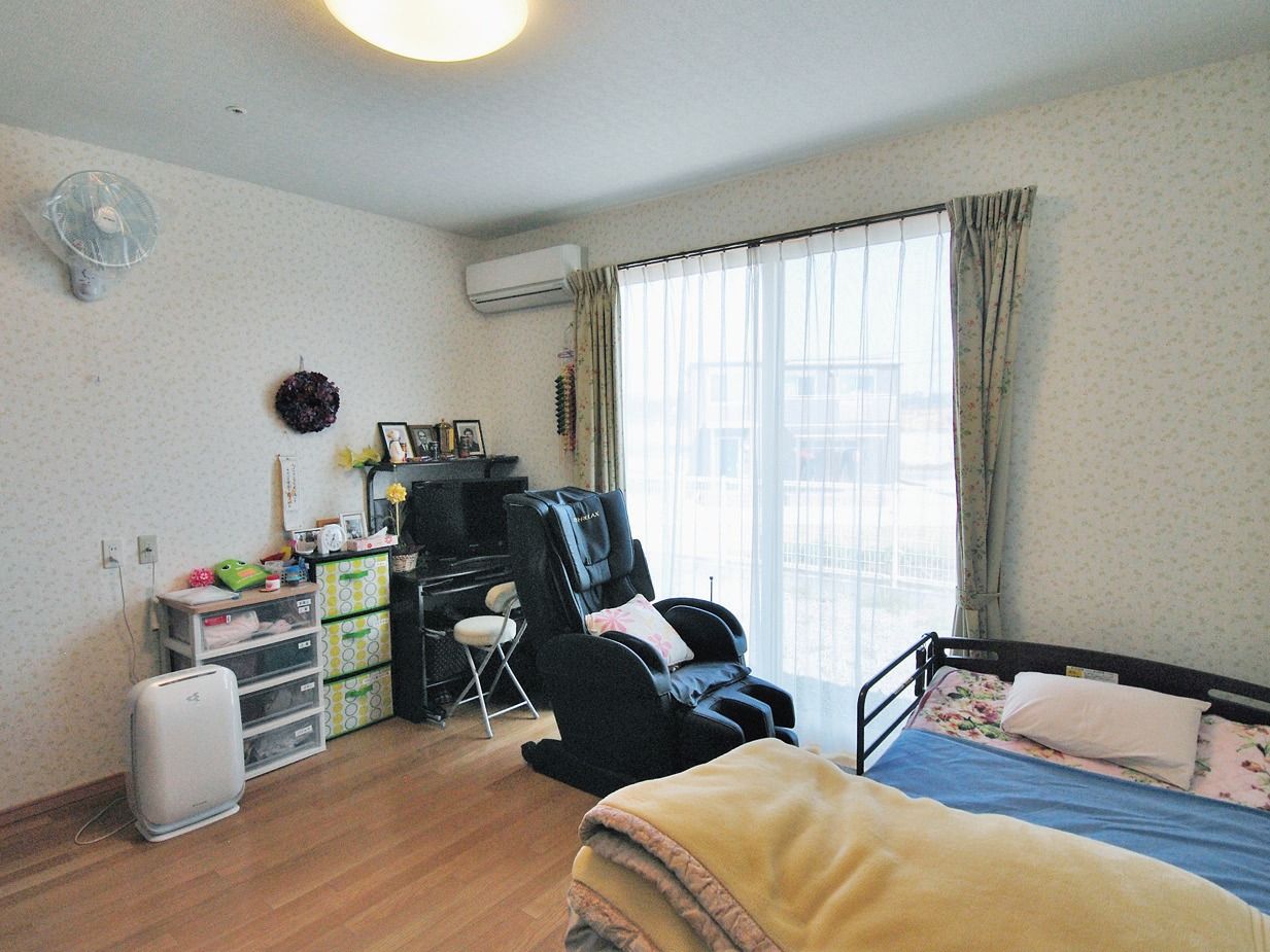 大きな介護ベッドやピアノを置いても、まだ十分な広さのある居室である。窓の外の景色を楽しめるマッサージチェアが置かれている。