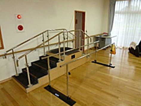 階段付きの平行棒などのリハビリ機器が置かれている機能訓練室