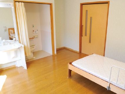 カーテンで仕切られたバリアフリー対応のトイレが備え付けられている部屋