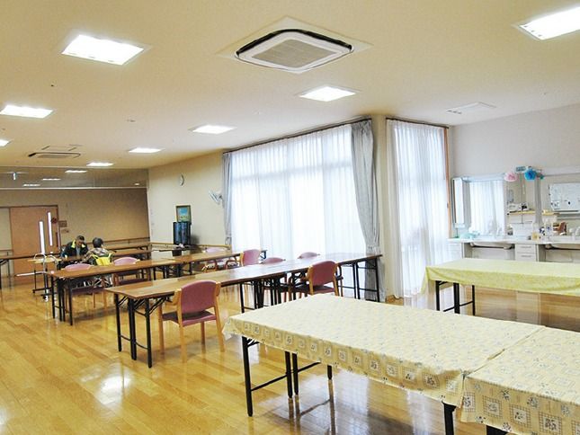 ゆったり食事ができる開放的な空間である。大きな掃き出し窓から自然光がはいり、明るい雰囲気。窓側には鏡が設置されている。