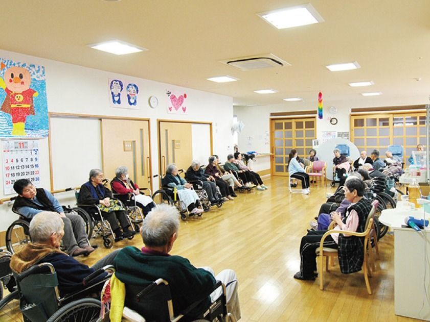 入居者様の交流の場所として利用されている。木のぬくもりが感じられる空間。壁には描かれたキャラクターの絵が飾られている。