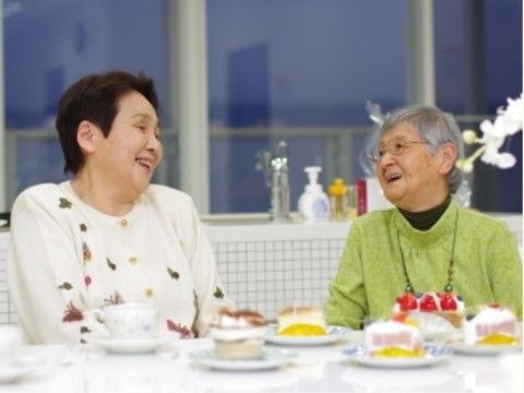 複数のケーキを目の前に、笑顔で談笑をする２人の女性