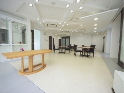 複数のテーブルと椅子が置かれている、明るく見晴らしの良い廊下