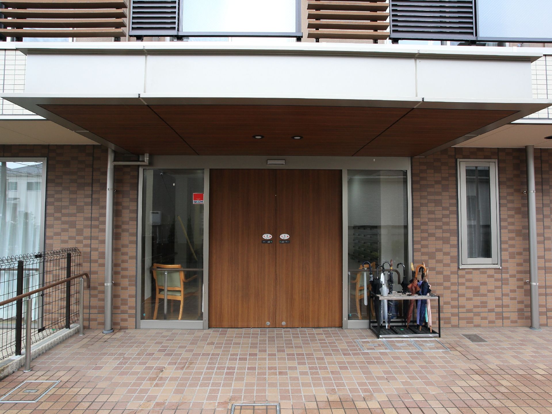 おしゃれな木目調の自動扉はマンションの入口のような印象。また屋根もあるので雨の日の車の乗り降りなども安心である。
