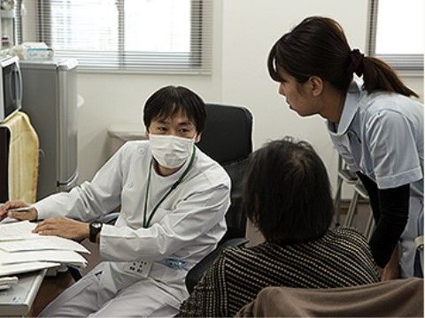 入居者様に寄り添う女性スタッフと、話を親身に聞く男性医師