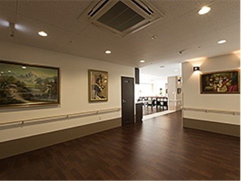 床はこげ茶色のフローリングになっている。壁に大きな絵が何点か飾られている。３方壁に囲まれた場所でも、照明があり明るい。